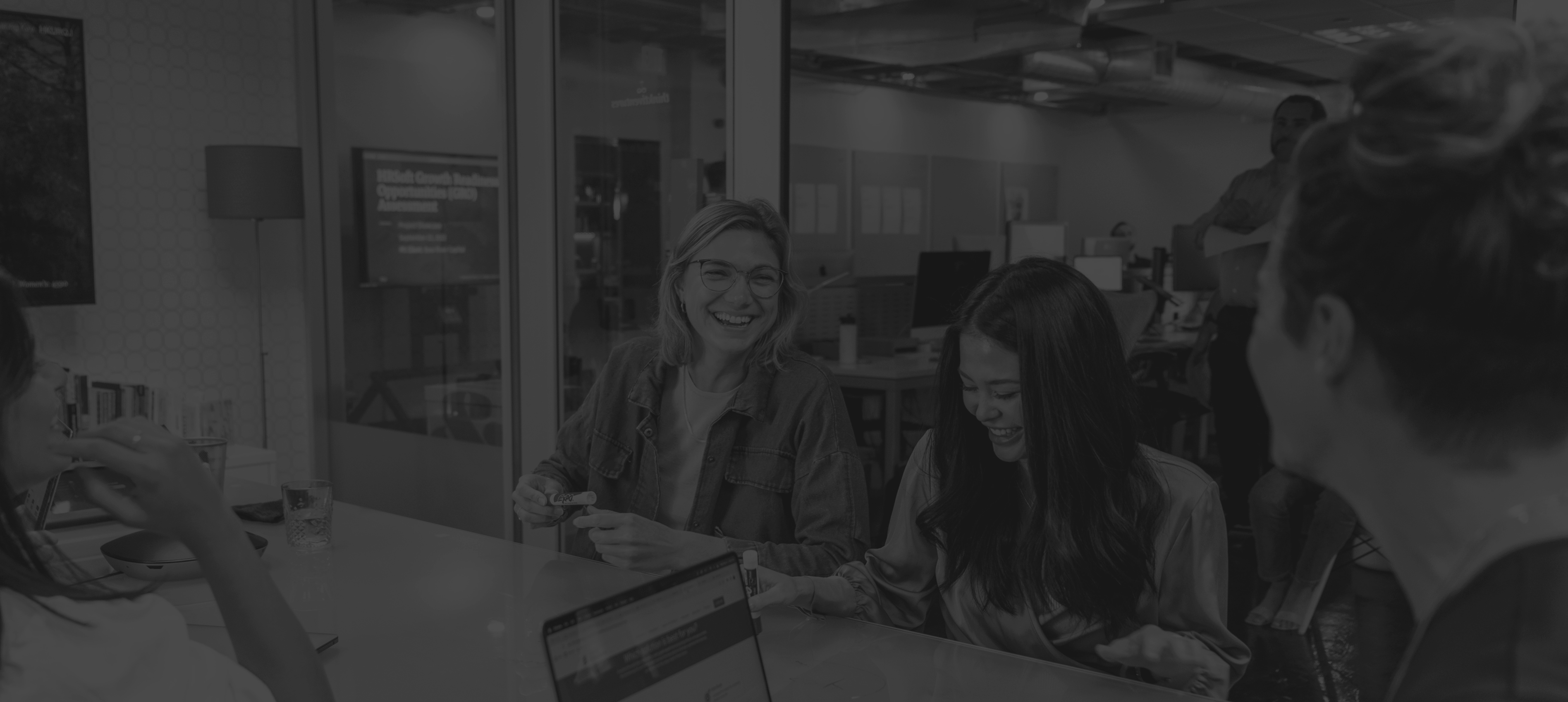 group of people in a conference room, smiling and working together
