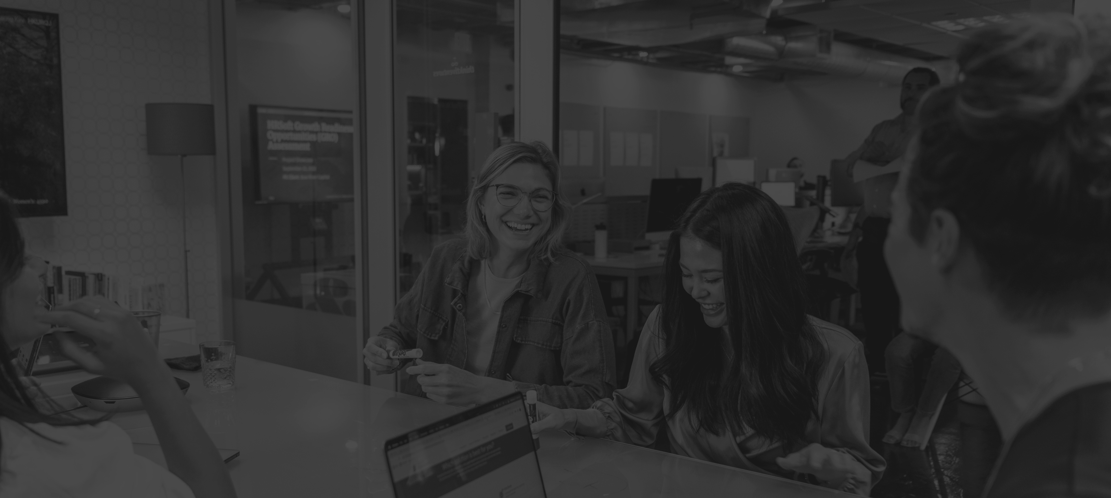 group of people in a conference room, smiling and working together 